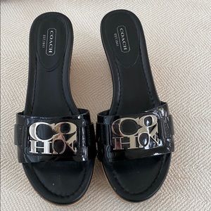 Black patent leather cork coach wedges.